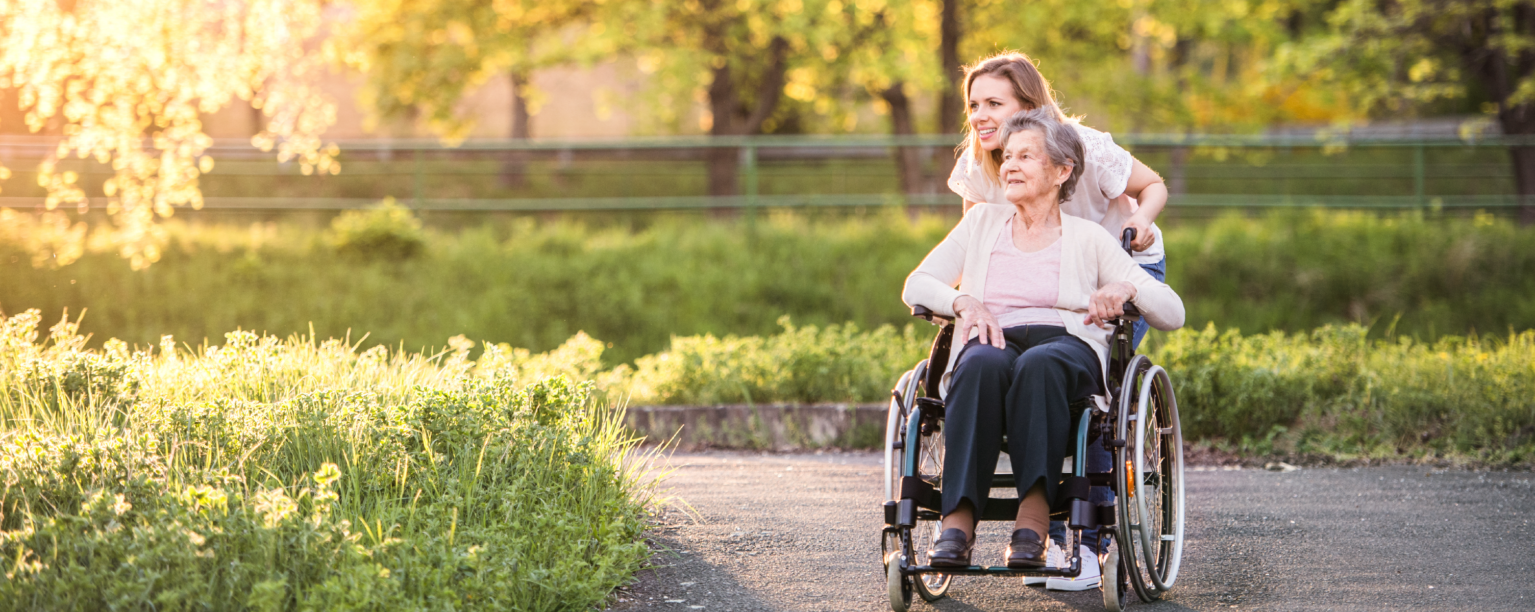 One woman pushing another in a wheelchair